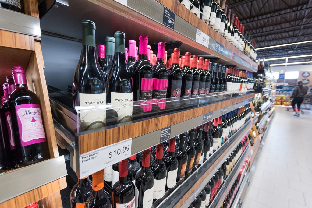 Hero shot of wine bottles on a shelf in a liquor store aisle